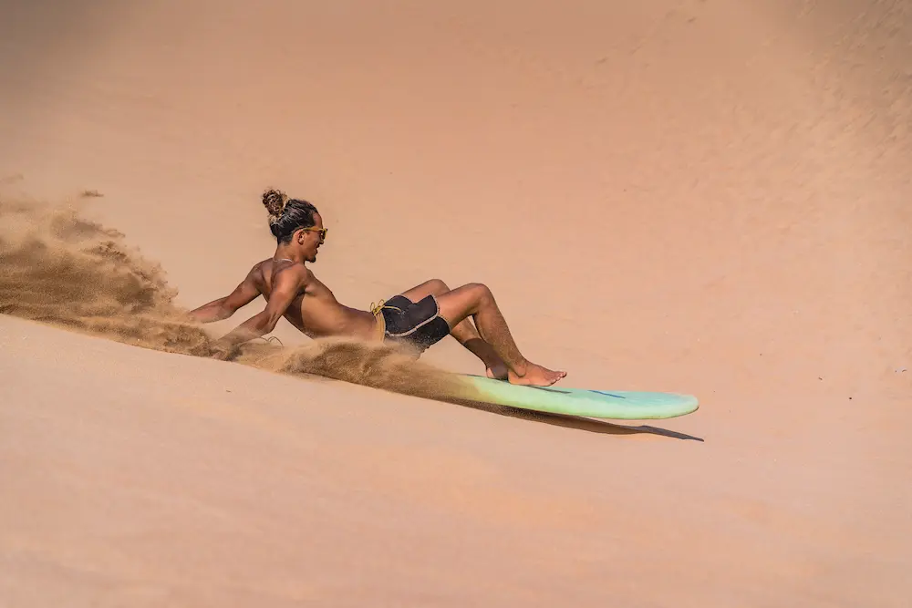 Sandboarding on the dunes, one of the things to do in Taghazout Bay, Morocco