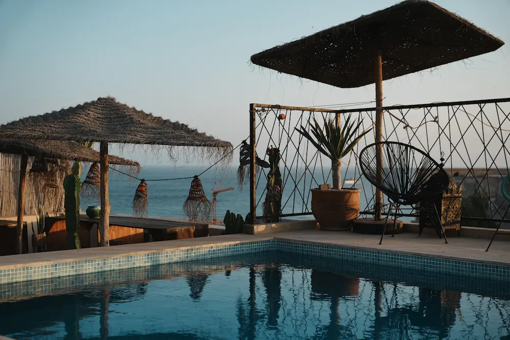 Rooftop pool with ocean view at The Yogi Surfer surf camp in Taghazout Bay, Morocco.