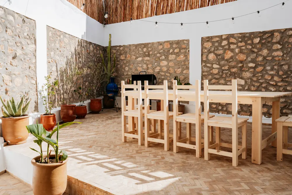 Villa Terrace Dining Area with Stone Walls at The Yogi Surfer in Taghazout Bay, Morocco.